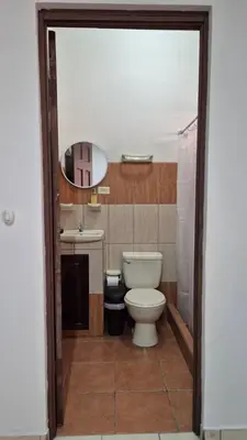 a bathroom with a toilet and a sink at Velaz Guesthouse in Alajuela City