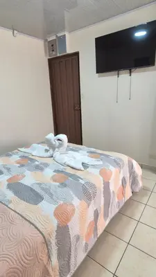 a bedroom with a bed with a colorful comforter at Velaz Guesthouse in Alajuela City