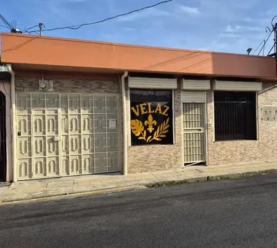 a building with a sign on the side of it at Velaz Guesthouse in Alajuela City
