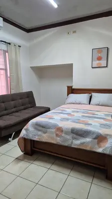 a bedroom with a bed and a couch at Velaz Guesthouse in Alajuela City