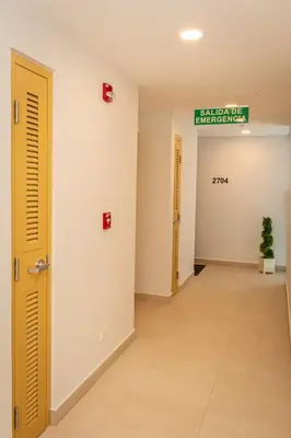 an empty hallway with two doors and a sign on the wall at Bird & Surf 2BD Retreat Jungle Views Pool Gym in Jacó