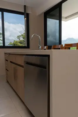a kitchen with a sink and some windows at Bird & Surf 2BD Retreat Jungle Views Pool Gym in Jacó