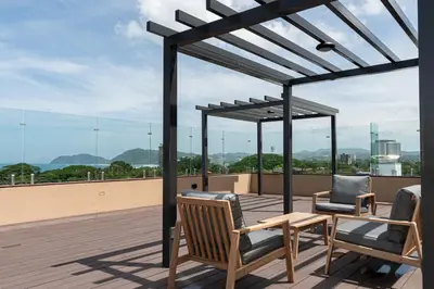 a patio with two chairs and a table on a roof at Bird & Surf 2BD Retreat Jungle Views Pool Gym in Jacó