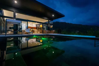 a house with a swimming pool at night at NEW Luxury! Panoramic views-Pool-Private-Gated in Portalón
