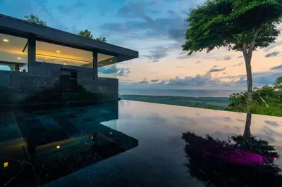 a house with a infinity pool and a tree at NEW Luxury! Panoramic views-Pool-Private-Gated in Portalón