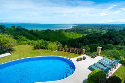 a swimming pool on a hill with a view of the ocean at 1hr SJO Airport-Ocean views-Gated Beachclub-Pool in Tarcoles