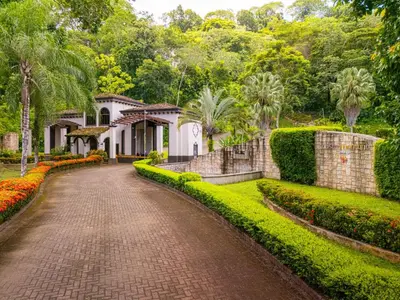 a brick driveway leading to a house with a garden at 1hr SJO Airport-Ocean views-Gated Beachclub-Pool in Tarcoles
