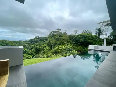 a swimming pool in a house with a view of trees at NEW! Modern-Luxury-3 suites-pool-Ojochal-100MBPS in Ojochal