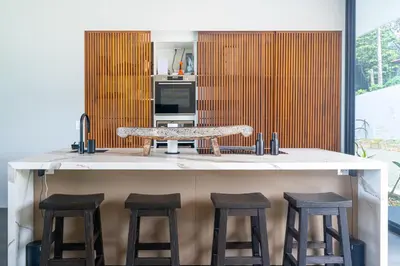 a kitchen with a counter with stools around it at NEW! Modern-Luxury-3 suites-pool-Ojochal-100MBPS in Ojochal