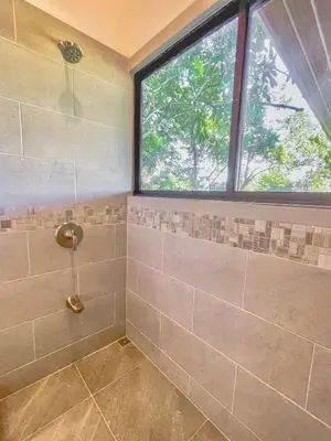 a bathroom with a shower with a window at 3 Suites-Views-Great pool-Near Dominical-Luxury in Laguna