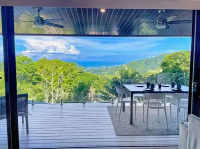 a table and chairs on a deck with a view at 3 Suites-Views-Great pool-Near Dominical-Luxury in Laguna