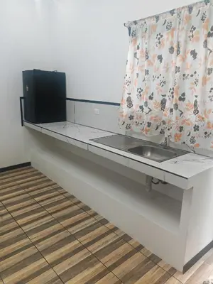 a kitchen counter with a sink and a curtain at Happy Family in Quepos