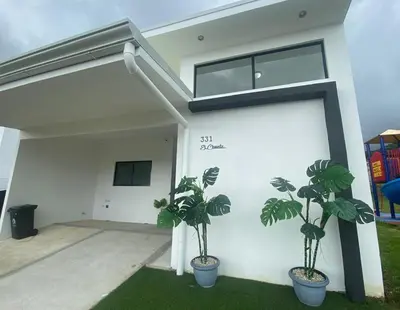 a house with two potted plants in front of it at El Chante cerca de playas, piscinas y vistas a la montaña in Herradura