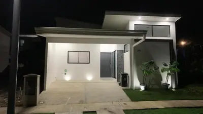 a white house with lights in the night at El Chante cerca de playas, piscinas y vistas a la montaña in Herradura