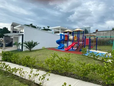 a playground in front of a white building at El Chante cerca de playas, piscinas y vistas a la montaña in Herradura