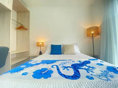 a bedroom with a bed with blue flowers on it at El Chante cerca de playas, piscinas y vistas a la montaña in Herradura