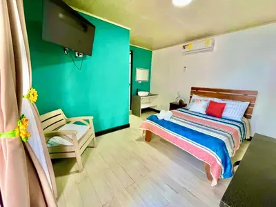 a bedroom with a bed and a flat screen tv at En-suite Paraiso #1 in Parrita