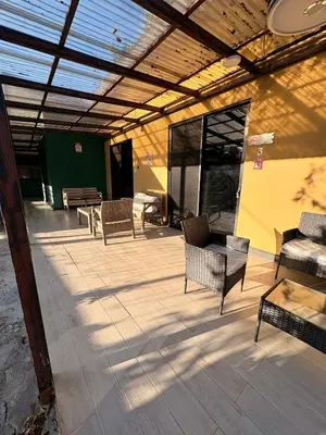 a patio with chairs and tables and a building at En-suite Paraiso #1 in Parrita