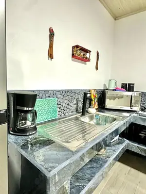 a kitchen with a counter top with a table at En-suite Paraiso #1 in Parrita