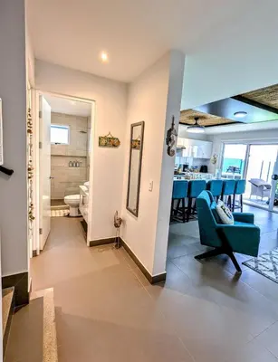 a living room with a blue couch and a dining room at Upscale Tropical Retreat - 4BR in Gated Resort in Jacó