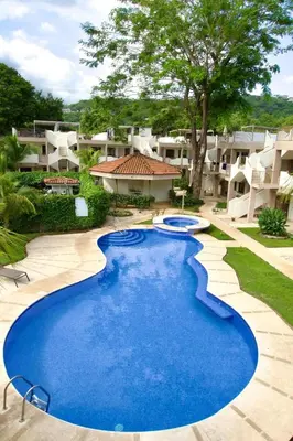a large blue pool in front of some apartments at Cozy Condo with Panoramic Hillside Views from Rooftop Terrace and Short Walk to Beach in Coco