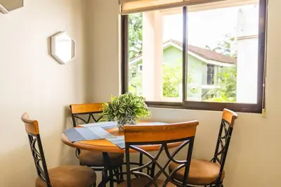 a dining room table with chairs and a window at Cozy Condo with Panoramic Hillside Views from Rooftop Terrace and Short Walk to Beach in Coco
