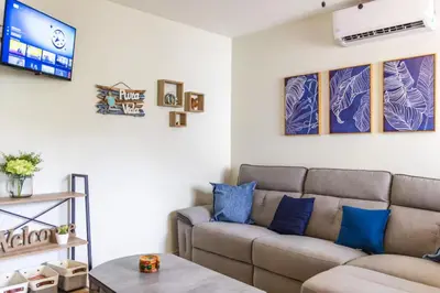 a living room with a couch and a tv at Cozy Condo with Panoramic Hillside Views from Rooftop Terrace and Short Walk to Beach in Coco