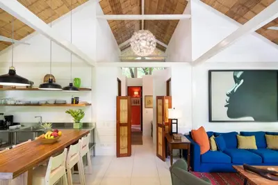 a living room with a blue couch and a table at Art Bungalow Walking distance to the beach in Santa Teresa Beach