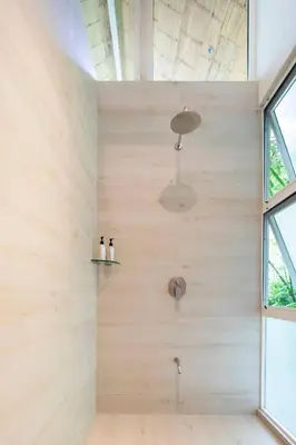 a bathroom with a shower with wooden walls at Art Bungalow Walking distance to the beach in Santa Teresa Beach