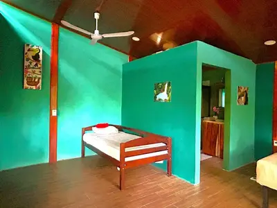 a room with a blue wall with a bed in it at Java blue banana in Santa Cruz
