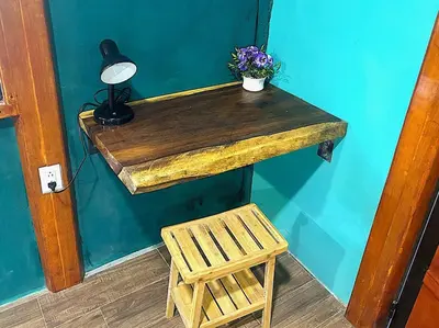 a wooden table with a plant and a lamp and a chair at Java blue banana in Santa Cruz