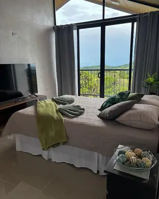 a bedroom with a bed with a window and a tray of food at Monteverde Sunset House in Cebadilla