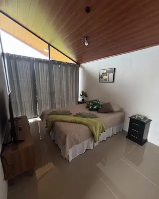 a bedroom with a bed and a television in it at Monteverde Sunset House in Cebadilla