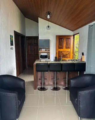 a kitchen with a counter and two bar stools at Monteverde Sunset House in Cebadilla