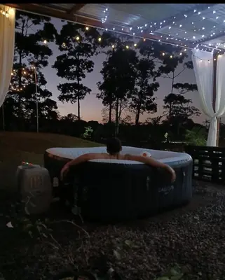 a man laying in a large tub under a tent at Tropical Crystal House in Guápiles
