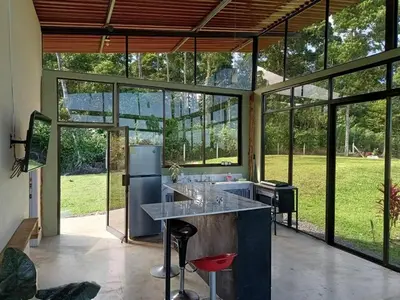 an open kitchen with a large kitchen island with stools at Tropical Crystal House in Guápiles