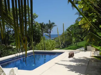 a swimming pool with a view of the ocean at Casas Pelicano in Playa Junquillal