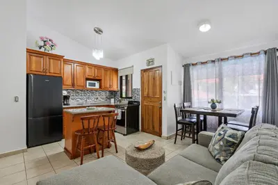 a kitchen and living room with a couch and a table at 2-BD Condo with Pool, Walk to Beach in Coco