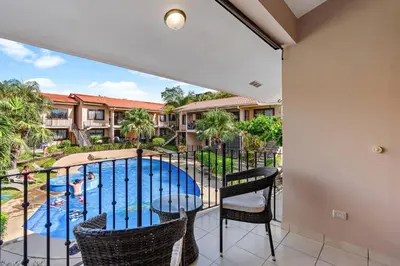 a balcony with a view of a swimming pool at 2-BD Condo with Pool, Walk to Beach in Coco