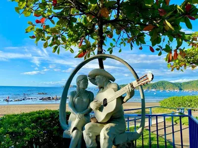 a statue of two people playing a guitar on the beach at 2-BD Condo with Pool, Walk to Beach in Coco