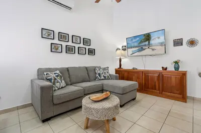 a living room with a couch and a tv at 2-BD Condo with Pool, Walk to Beach in Coco