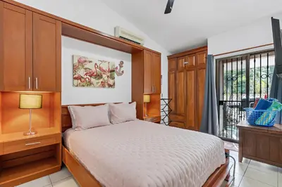 a bedroom with a bed and a window at 2-BD Condo with Pool, Walk to Beach in Coco