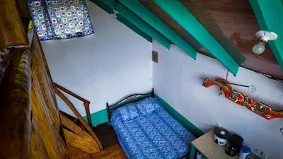 a small room with a bed and a car on the wall at Finca Buena Vista in Turrialba