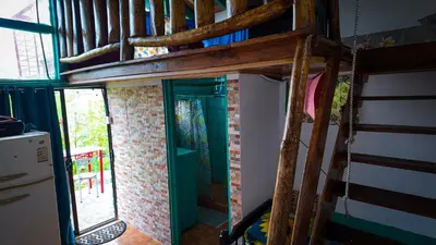 a loft bed in a room with a window at Finca Buena Vista in Turrialba