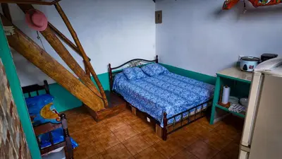 a small bedroom with a bed and a staircase at Finca Buena Vista in Turrialba