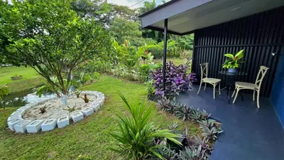 a patio with a table and chairs and a tree at Casa del Lago in Bijagua