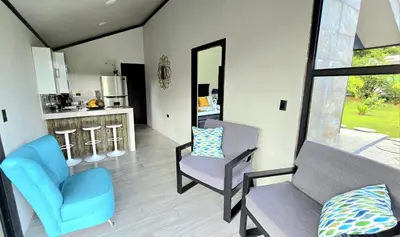 a living room with two chairs and a mirror at Casa del Lago in Bijagua