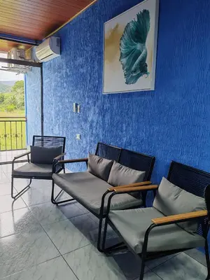 a room with two chairs and a blue wall at YAIZA HOUSE Jaco in Jacó