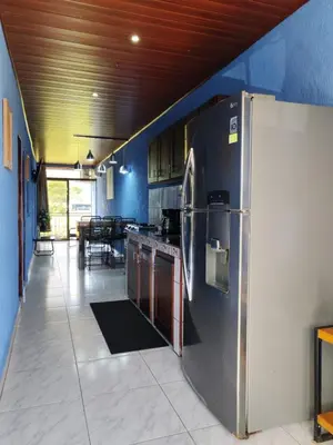 a kitchen with a large refrigerator in a room at YAIZA HOUSE Jaco in Jacó