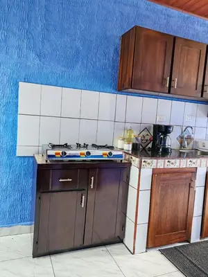 a kitchen with wooden cabinets and a stove top oven at YAIZA HOUSE Jaco in Jacó